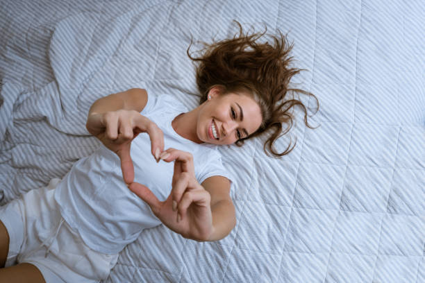 istock Happy young woman wake up in comfortable white bed 1421536339