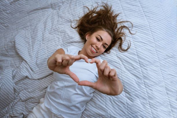 istock Happy young woman wake up in comfortable white bed 1421536391