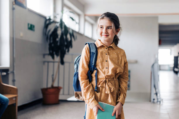 istock portraits of happy elementary schoolgirl holding workbook 1421536565