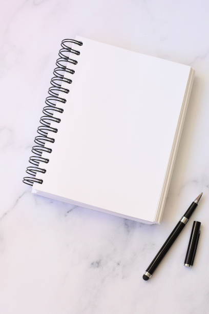 istock Open notebook and black pen, blank paper, mock up 1421541441