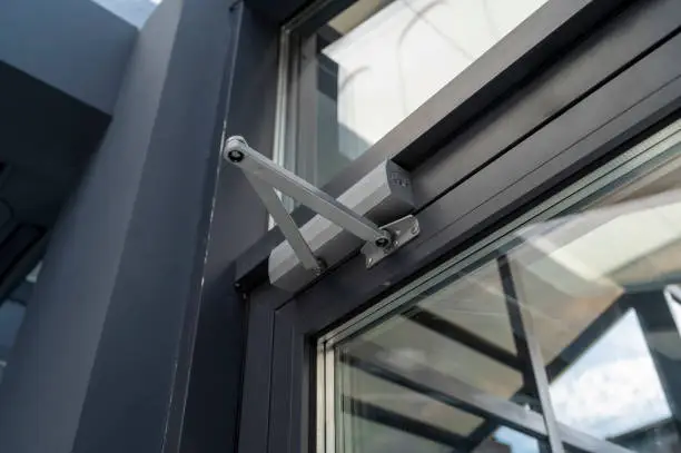 lever door closer in the office, a device for controlling the process of opening and closing the door, shot close-up