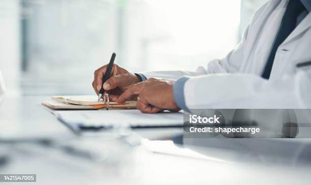 Doctor Hands Writing On Paper Or Document At A Desk In The Hospital Healthcare Professional Drafting A Medical Insurance Letter Legal Paperwork Or Form A Gp Filing A Document In A Clinic Office Stock Photo - Download Image Now