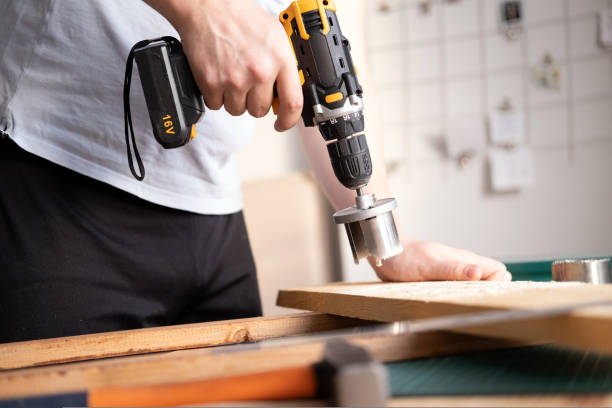 istock Home workshop. Close-up of a man in goggles working with a drill. 1421547327