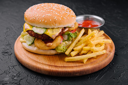 Juicy burger with onion rings and french fries