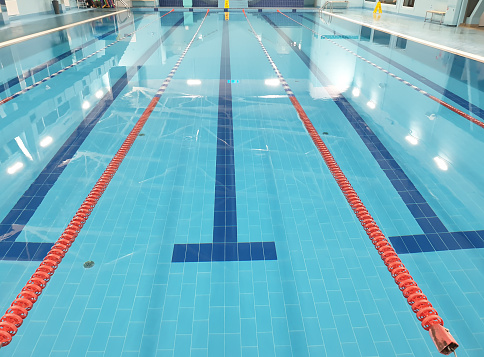 Close-up View Of Indoor Swimming Pool With Swimming Lane Markers And Diving Boards