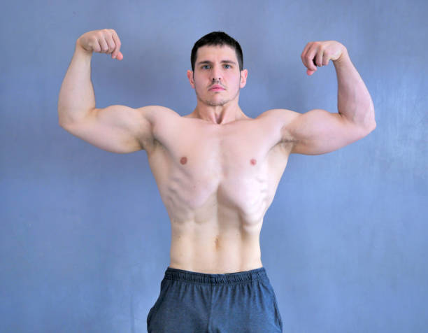 sehr muskulöse männerposen zeigen seine muskeln. - men macho flexing muscles shirtless stock-fotos und bilder