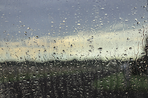 rain on car window and winter landscape