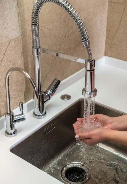 istock Hands with palms full of tap water in the kitchen 1421554882