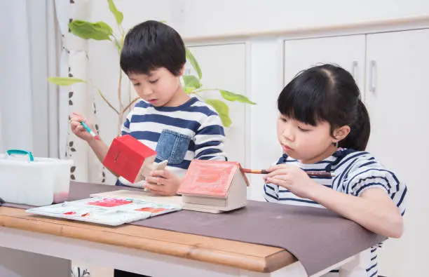 Japanese elementary school students coloring their work with paints
