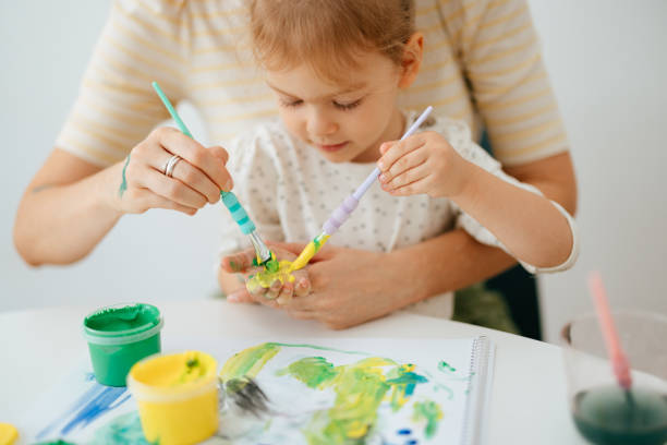 istock Anonymous Mother and Preschool Daughter Playing and Being Creative With Paint 1421557898