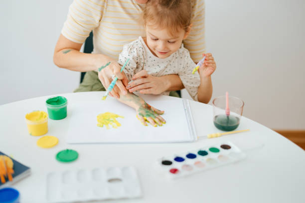 istock Anonymous Mother and Cute Daughter Playing and Being Creative With Paint 1421557904