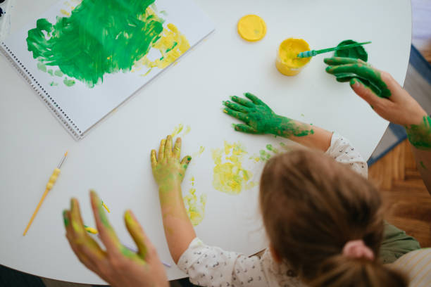 istock Anonymous Woman and Child Making Handprints With Paint at Home 1421557936