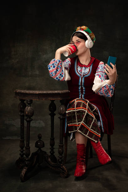 retrato creativo de una hermosa mujer ucraniana con trajes folclóricos tradicionales aislados sobre un fondo vintage oscuro. tradiciones, historia, moda, belleza, - ukrainian culture audio fotografías e imágenes de stock