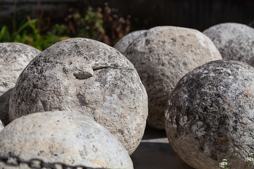 Large vintage stone cannon balls on a blurred background.