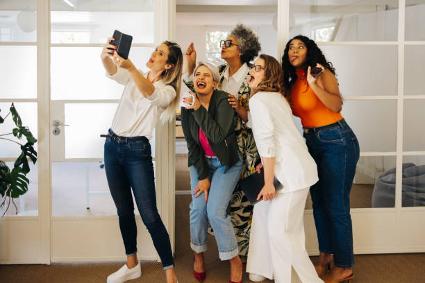 istock Diverse businesspeople taking a group selfie in an office 1421565365