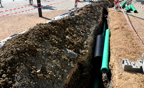 istock laying high voltage cables ground. environment does not damage electric poles. Excavation meter deep in ground black plastic coated strong cable wires. risk of electric shock, telephone, outdoor, lawn 1421565885