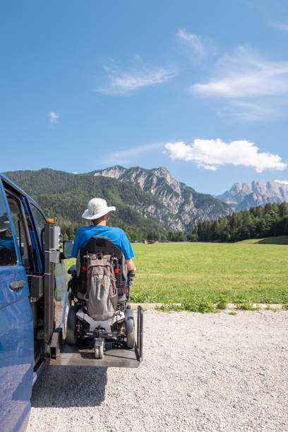 Man with disability using wheelchair lift to get in the van Man with disability using hydraulic wheelchair lift to get in the van, after a summer day spent on beautiful mountain nature wheelchair lift stock pictures, royalty-free photos & images