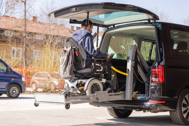 istock Man with disability using wheelchair lift to get in the van 1421571763