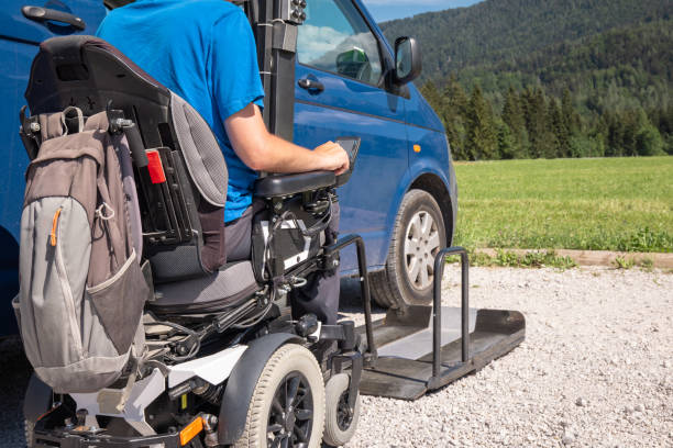 istock Man with disability getting off a van, using a wheelchair lift 1421571864