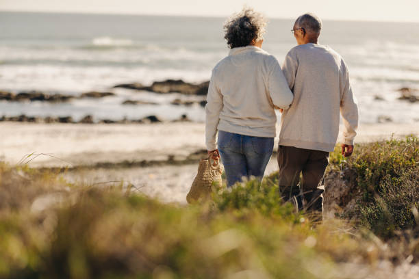 istock Romantic senior couple going to the beach for a picnic 1421572505