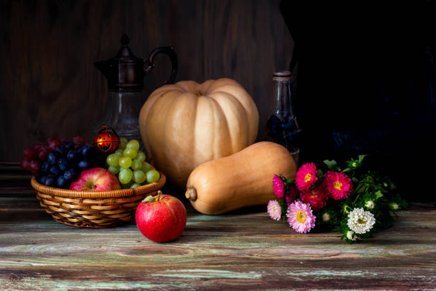 Halloween concept. Still Life with pumpkin, apples and a grapes on wooden background close-up.