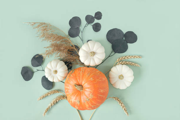 istock Autumn composition. Green desk with pumpkins and eucalyptus branch. Flat lay, top view, copy space. Nordic, hygge, cozy home concept. Thanksgiving fall decoration. Halloween Modern Invitation Mock up. 1421572782