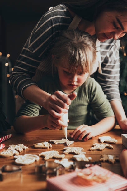 istock Christmas, New Year food preparation. Gingerbread cookies decorating with icing 1421574481