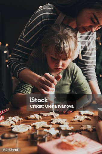 istock Christmas, New Year food preparation. Gingerbread cookies decorating with icing 1421574481