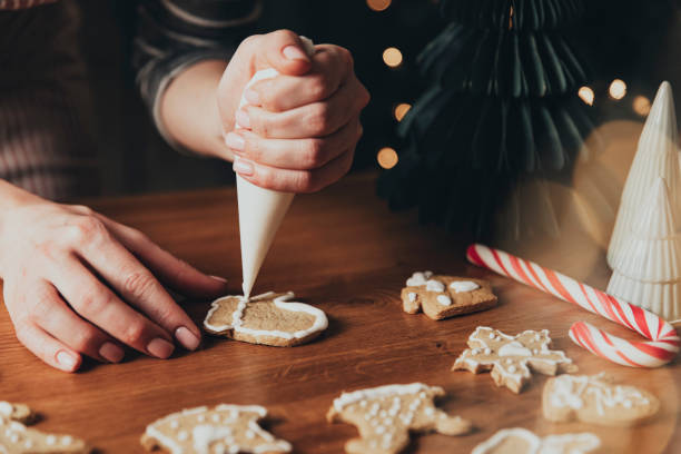 istock Christmas, New Year food preparation. Gingerbread cookies decorating with icing 1421574486