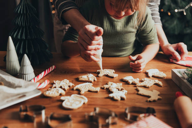 istock Christmas, New Year food preparation. Gingerbread cookies decorating with icing 1421574490