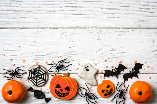 istock Halloween sweets and decorations on white wood background, top view 1421578187