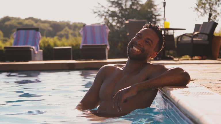 Portrait Of Smiling Man On Summer Holiday Or Vacation Relaxing In Swimming Pool