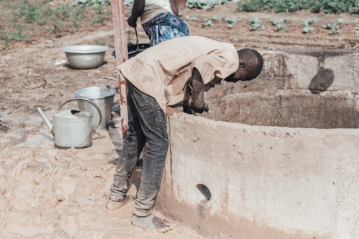 Ouagadougou, Burkina Faso. December 2017.Due to the drought, water is a rare and precious commodity in Burkina Faso. In this image some farmers draw water from a well