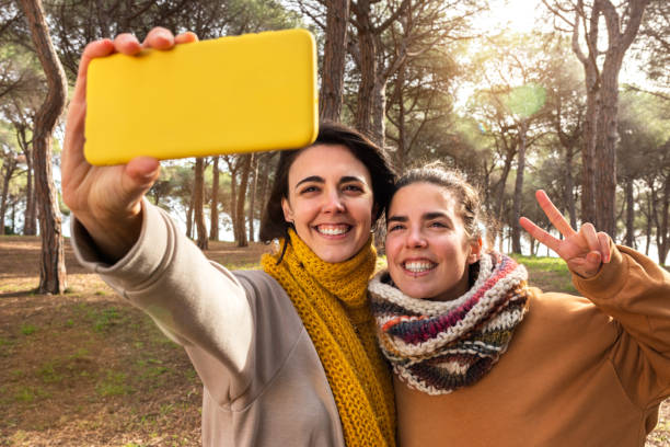 istock Happy young women take selfie using mobile phone during a walk in the forest. 1421586106