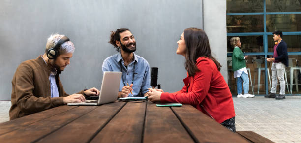 istock Young influencers create content on outdoors terrace. Millennial content creators recording podcast. 1421586119