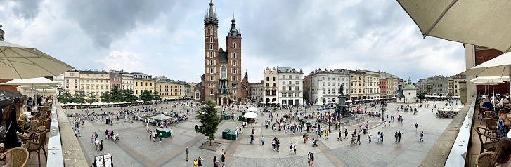 St Mary's Basilica and surrounding buildings in Rynek Główny medieval main square panorama, Krakow, Poland. Krakow city in Poland was originally the capital of the country until 1956 but is now best known for its well-preserved medieval centre with its period architecture and spacious Rynek Glówny market square as well as the Jewish quarter and ghetto areas.