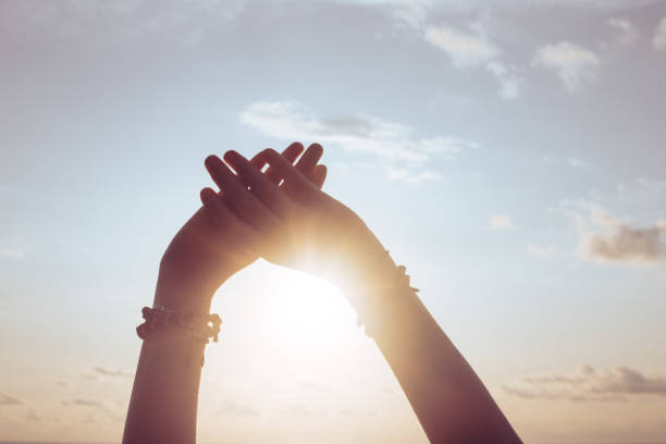 istock Woman hands against blue sky and sun 1421587963