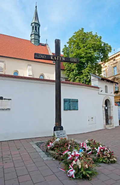 Katyn Forest Memorial cross and offerings, Krakow. The Katyn Forest massacre was a series of 22,000 executions of intelligentsia and Polish Officers carried out in April and May 1940 by the Russian NKVD. Krakow city in Poland was originally the capital of the country until 1956 but is now best known for its well-preserved medieval centre with its period architecture and spacious Rynek Glówny market square as well as the Jewish quarter and ghetto areas.