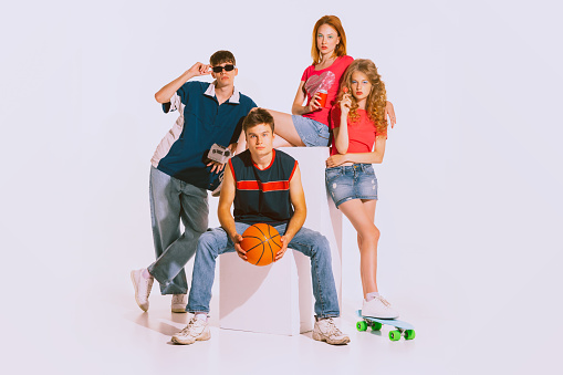 Group of young stylish people, students, boys and girls posing isolated on grey background. Style of 90s years. Bright makeup. Jeans style. Youth, retro style, 90s era, fashion, lifestyle, ad concept
