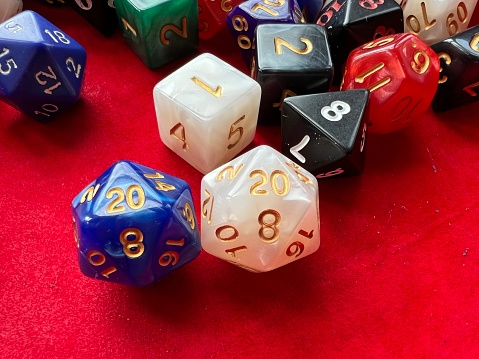 A host of role-playing dice with white and blue D20 for dungeons and dragon  in a leather and velvet rolling box
