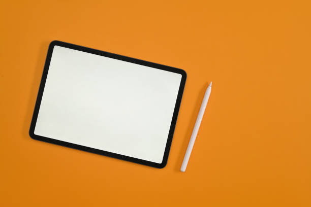 istock Top view with empty screen of digital tablet, tablet and stylus pen on yellow studio background. 1421592517