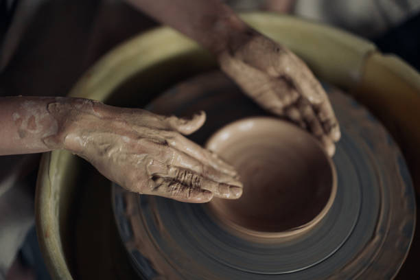 istock Hands of potter sculpt handmade earthenware on spinning pottery wheel. 1421592708