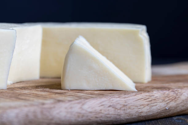 istock Fresh cow's milk cheese is cut on a board 1421593106