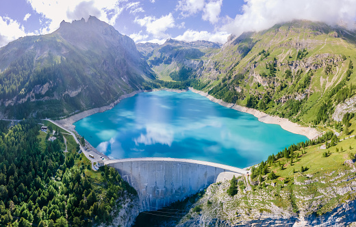 Presa de agua y lago embalse en las montañas de los Alpes suizos que producen energía hidroeléctrica sostenible, generación de hidroelectricidad, energía renovable para limitar el calentamiento global, vista aérea, descarbonización, verano photo