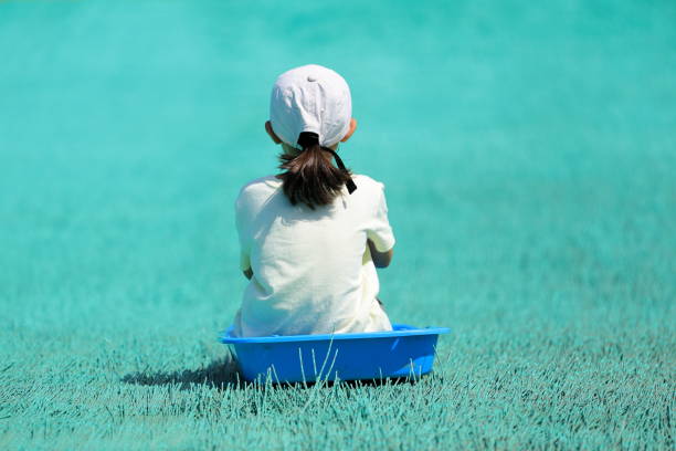 Japanese student girl on the grass sledge (7 years old)