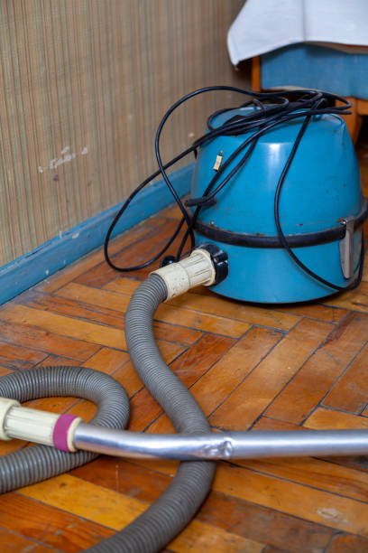 istock Blue vacuum cleaner stands on old parquet floor 1421601933