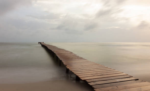 푸른 시간에 바다에있는 목조 다리의 긴 노출 - boardwalk pontoon bridge landscape sky 뉴스 사진 이미지