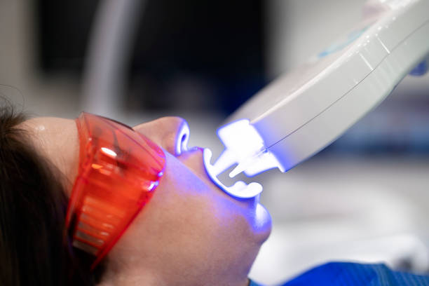 istock Woman Doing Tooth Whitening Treatment 1421603676