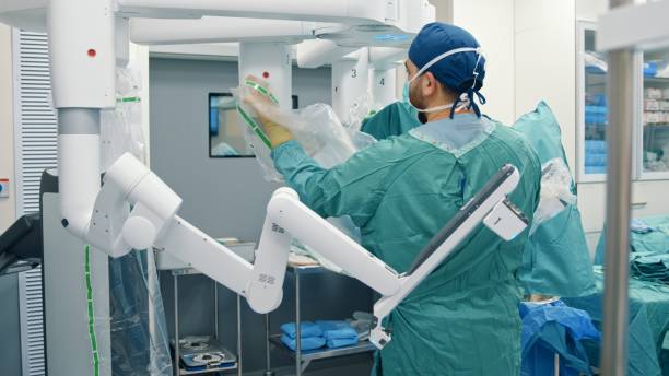 Operating room nurse preparing a surgical robot for  surgery stock photo