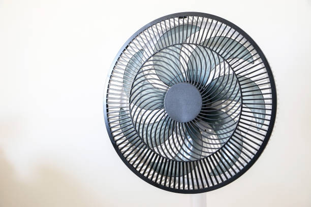 istock A spinning black electric fan isolated on right against white wall, cooling down interior during summer heat waves and rising temperatures 1421605720